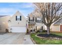 Charming two-story home featuring a well-manicured lawn and a classic American flag accent at 417 Galesburg Dr, Monroe, NC 28110