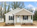 Inviting home featuring a gabled roof, neutral siding, black shutters, and a cozy front porch with white railings at 419 N Caldwell St # 1, Salisbury, NC 28144