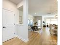 Open concept dining area with wood floors, a dining table and chairs, and bright natural light coming through the windows at 527 Morrows Turnout Way, Pineville, NC 28134