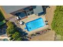 Aerial view of the pool and backyard area, with seating, a manicured lawn and mature trees at 5608 Old Town Ln, Gastonia, NC 28056