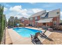 Beautiful in-ground pool with a lounge area, outdoor kitchen, and well-maintained landscaping at 5608 Old Town Ln, Gastonia, NC 28056