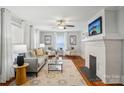 Cozy living room with hardwood floors, a fireplace, large windows, and comfortable seating at 1105 Vanizer St, Charlotte, NC 28208