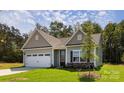 Charming single-story home featuring a two-car garage, stone accents, and a well-manicured lawn at 111 Tradesmen Trl # 75, Troutman, NC 28166