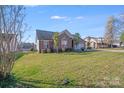 Attractive single-story brick home with lush green lawn, red shutters, and a welcoming neighborhood setting at 1232 Pressley Downs Se Dr, Concord, NC 28025