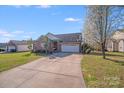 Inviting single Gathering home featuring a brick facade, two car garage, and a long driveway at 1232 Pressley Downs Se Dr, Concord, NC 28025