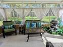 Enclosed sun room with wicker furniture, a decorative waterfall, and a view of the backyard at 12421 Poplar Forest Dr, Charlotte, NC 28278