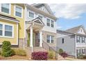 Townhome featuring a brick facade, light gray siding, and an inviting covered porch at 12461 Bryton Ridge Pkwy, Huntersville, NC 28078