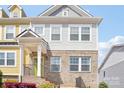 Exterior elevation of a townhome featuring brick facade, light gray siding, and covered porch at 12461 Bryton Ridge Pkwy, Huntersville, NC 28078