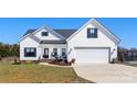 Charming two-story home with white siding, black shutters and a well-manicured lawn at 1323 Stack Rd, Monroe, NC 28112