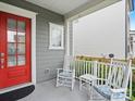 Inviting front porch with rocking chairs, cushions, and a red door offers a relaxing outdoor space at 13923 Jacks Ln, Pineville, NC 28134