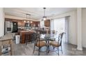 Eat-in kitchen featuring dark wood cabinets, stainless steel appliances, and a glass-top dining table at 203 Waterlemon Way, Monroe, NC 28110