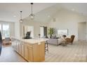 Bright open-concept living room with vaulted ceilings and a modern island with bar stool seating at 2355 Emanuel Church Rd, Rockwell, NC 28138