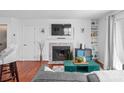 Cozy living room with a fireplace, mounted TV, and built-in shelving at 525 N Graham St # 2F, Charlotte, NC 28202