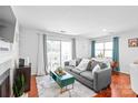 Bright living room with a cozy gray sofa, fireplace and sliding glass doors to outdoor living at 525 N Graham St # 2F, Charlotte, NC 28202