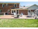 Back of brick home overlooking backyard, featuring outdoor deck with seating and a fire pit at 6411 Boykin Spaniel Rd, Charlotte, NC 28277