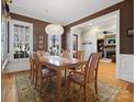 Elegant dining room featuring hardwood floors, a chandelier, and a view into the living room fireplace at 8416 Highgrove St, Charlotte, NC 28277