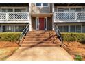 Inviting entryway with brick steps that lead to a vibrant red door and well-maintained landscaping at 9405 Old Concord Rd # G, Charlotte, NC 28213
