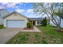 Charming one-story home with attached garage, tidy lawn and mature tree in established neighborhood at 10130 Illoria Dr, Charlotte, NC 28273