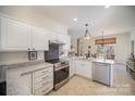 Well-lit kitchen with stainless steel appliances, granite countertops, and white cabinets at 10502 Orchid Hill Ln, Charlotte, NC 28277