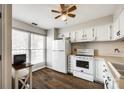 Functional kitchen featuring white cabinets, a stove, refrigerator, and a window for natural light at 10961 Carmel Crossing Rd, Charlotte, NC 28226