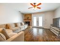 Inviting living room features a brick fireplace, a comfortable sofa and bright lighting through the patio doors at 10961 Carmel Crossing Rd, Charlotte, NC 28226