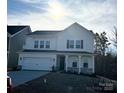 Charming two-story home boasts a two-car garage, white siding, and a well-manicured front yard at 1439 Hubert Graham Way, Tega Cay, SC 29708