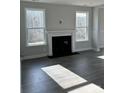 Cozy living room showcasing a fireplace, abundant natural light, and hardwood floors at 1439 Hubert Graham Way, Tega Cay, SC 29708
