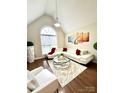 Bright living room with vaulted ceilings, a large window, and a white sectional sofa with red pillows at 205 Edenshire Ct, Indian Trail, NC 28079