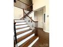 Elegant staircase with hardwood steps, wrought iron railings, and a wood banister at 205 Edenshire Ct, Indian Trail, NC 28079