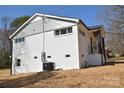 Exterior side view of a renovated home featuring white painted brick and updated siding at 244 Stilwell Oaks Cir, Charlotte, NC 28212