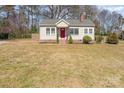 Charming single-story home featuring a red front door, chimney, and well-maintained lawn at 27 Liske Nw Ave, Concord, NC 28027