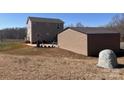 A detached building with an outdoor patio area creates extra space for parking and gardening at 3032 Morning Glory Ln, Vale, NC 28168