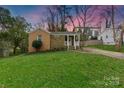 A charming single-story home with stone and brick accents, a front porch, and green lawn at 4010 Hiddenbrook Dr, Charlotte, NC 28205