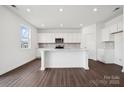 A modern kitchen with white cabinets, an island, quartz countertops, and stainless steel appliances at 557 Mountain View Dr, Monroe, NC 28110