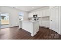 Modern kitchen featuring an island, quartz countertops, sleek white cabinets and stainless steel appliances at 557 Mountain View Dr, Monroe, NC 28110