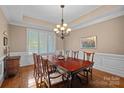 Formal dining room featuring a large table, elegant lighting, and plantation shutters for a bright atmosphere at 8724 Highgrove St, Charlotte, NC 28277