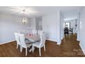 Formal dining room with hardwood floors, modern light fixture, and seating for six at 10114 Turkey Point Dr, Charlotte, NC 28214