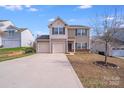 Neutral siding and a two-car garage highlight this two-story home at 105 Abel Peterson Dr, Mount Holly, NC 28120