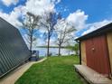 Exterior view of the home and shed, situated on a picturesque lot with waterfront views at 120 Ole Point Ln, Salisbury, NC 28146