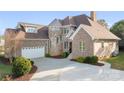 Beautiful brick home with turret, attached garage, and concrete driveway at 121 Dabbling Duck Cir, Mooresville, NC 28117