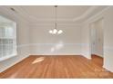 A pristine dining room with hardwood floors and a modern chandelier at 12724 Hunting Birds Ln, Charlotte, NC 28278