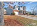 Two-story home with brick, stone, gray siding, and a 2-car garage at 12724 Hunting Birds Ln, Charlotte, NC 28278