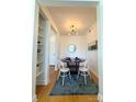 Elegant dining room featuring hardwood floors, a modern chandelier, and an adjacent living area at 1315 East Blvd # 328, Charlotte, NC 28203