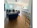 Bright and spacious living room with hardwood floors, a ceiling fan, and access to outdoor balcony at 1315 East Blvd # 328, Charlotte, NC 28203