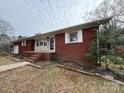 A classic single-story brick home with a well-maintained front yard and a charming decorative bicycle at 1575 Simplicity Rd, Concord, NC 28025