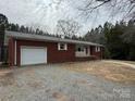 A traditional single-story brick home featuring an attached garage and a paved driveway at 1575 Simplicity Rd, Concord, NC 28025