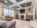 Comfortable living room featuring built-in shelving, a fireplace, dark wood floors and coffered ceilings at 1708 Royal Gorge Ave, Charlotte, NC 28210