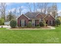 Lovely brick home with well-manicured lawn, complemented by lush landscaping and mature trees at 2019 W Laporte Dr, Charlotte, NC 28216