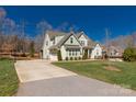 View of the home with a long driveway leading to an attached garage, surrounded by trees at 233 Catawba Crest Ln, Clover, SC 29710