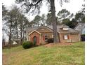 Single-story home with brick and tan siding, red shutters, and a well-maintained lawn in a wooded setting at 2517 Bushy Pine Ct, Charlotte, NC 28273